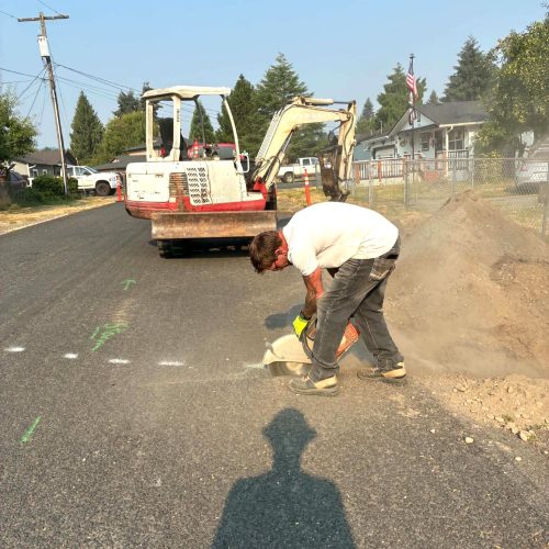 Plumber cutting pavement for residential sewer line replacement in Castle Rock