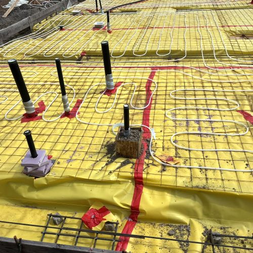 Hydronic radiant floor heating tubing secured before concrete slab pour